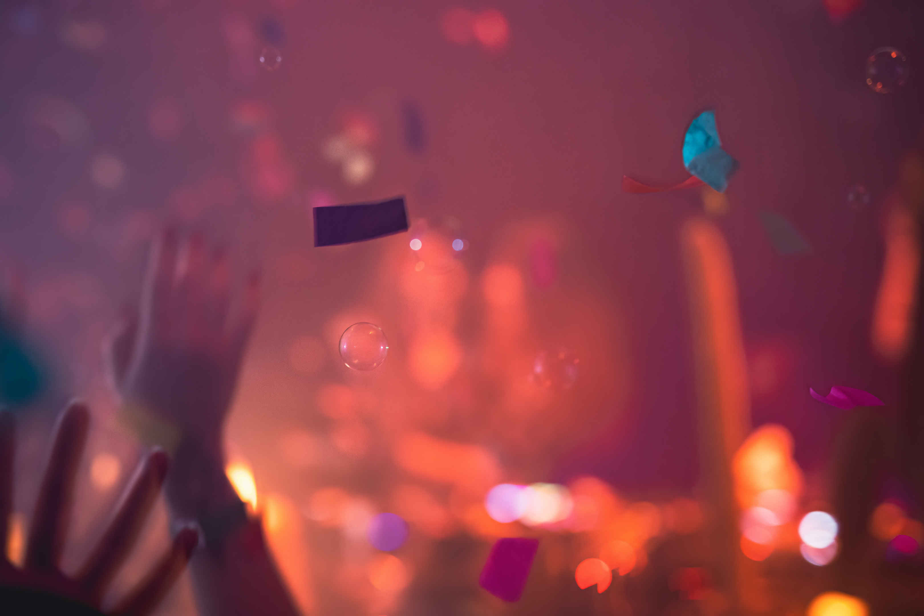 Des silhouettes de mains dans les airs entourés de bulles et confettis, on devine qu'il s'agit d'un événement où les gens sautent de joie